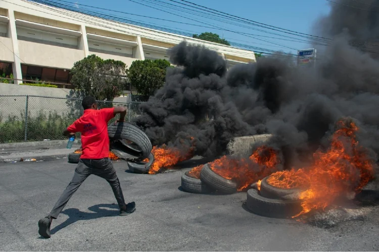 Manifestante queima pneus durante manifestação após a demissão do primeiro-ministro Ariel Henry, em Porto Príncipe, Haiti (Jean-Daniel SENAT com Gerard MARTINEZ em Miami/AFP Photo)