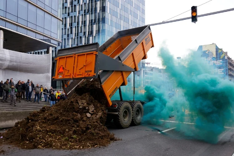 Agricultores despejam terra durante protesto em Bruxelas (AFP)