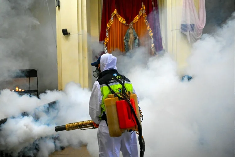 Um funcionário municipal pulveriza contra o mosquito Aedes aegypti, vetor dos vírus dengue, zika e chikungunya, como medida preventiva na igreja Las Misericordias, na Cidade da Guatemala (AFP)