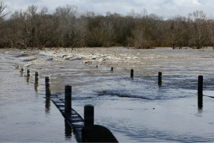 Ponte engolida pela água devido à inundação do rio Gard, em 10 de março de 2024, na cidade de Dions, sudeste da França (AFP Photo)