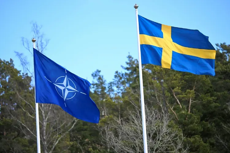 Suécia: em uma cerimônia realizada sob garoa persistente, o secretário-geral da aliança militar, Jens Stoltenberg, içou a bandeira ao lado do primeiro-ministro sueco (AFP/AFP Photo)