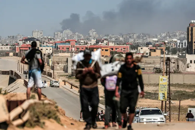 Palestinos fogem em meio à fumaça sobre o hospital Al Shifa e seus arredores, na Faixa de Gaza. (AFP/AFP)