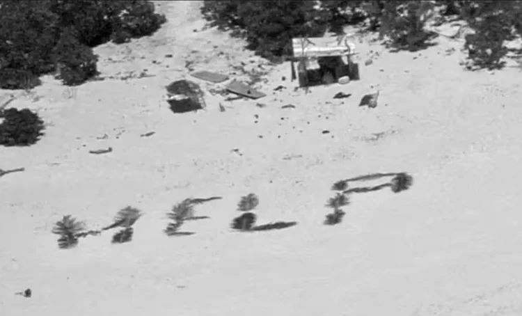 Palavra 'help' (socorro, em português) foi escrita na areia com folhas de palmeira. ( US Coast Guard Forces Micronesia/-)