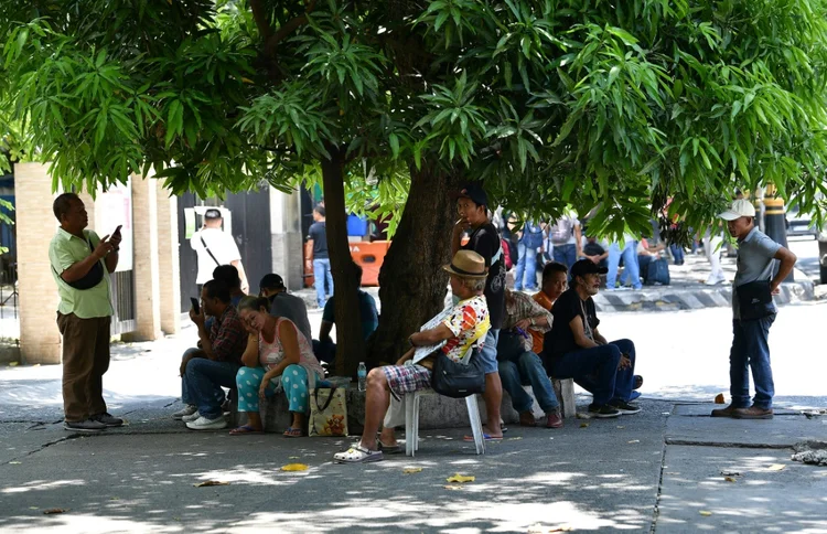 Refresco: em lugares como Manilla, quem precisa trabalhar na rua tenta se proteger sob a sombra de árvores (afp/AFP Photo)