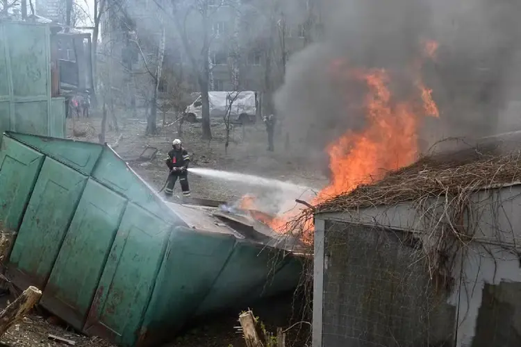 Bombeiros tentam apagar incêndio causado por ataque russo em Kharkiv, na Ucrânia (SERGEY BOBOK/AFP Photo)