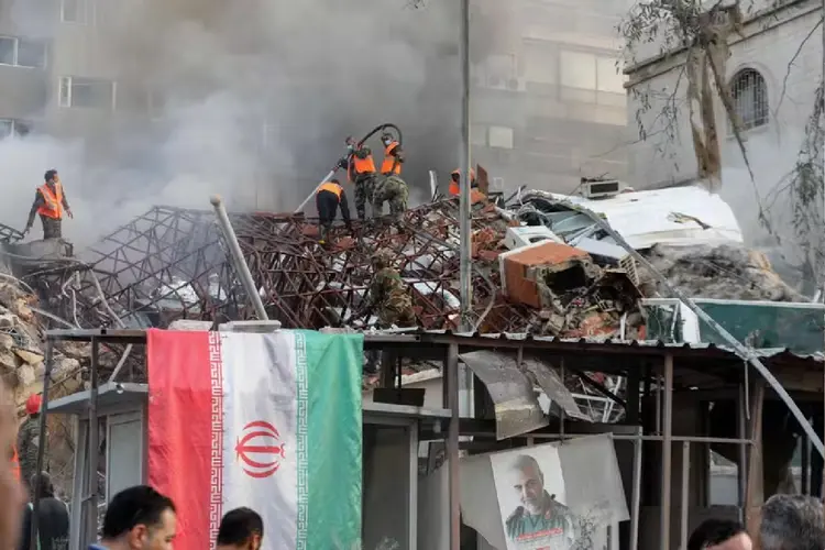 Bombeiros tentam extinguir focos de incêndio no prédio do Consulado do Irã em Damasco  (LOUAI BESHARA/AFP)