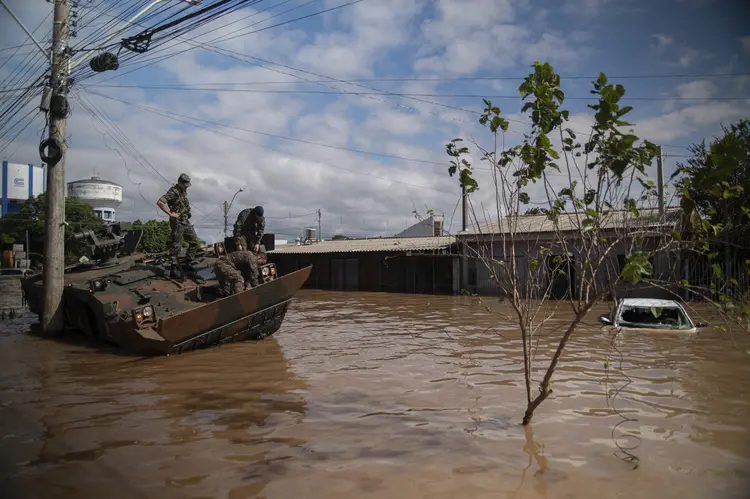 Army soldiers observe their damaged vehicle at a flooded street of Eldorado do Sul, Rio Grande do Sul state, Brazil on May 9, 2024. Teams raced against the clock Thursday to deliver aid to flood-stricken communities in southern Brazil before the arrival of new storms forecast to batter the region again. Some 400 municipalities have been affected by the worst natural calamity ever to hit the state of Rio Grande do Sul, with at least 107 people dead and hundreds injured. (Photo by Carlos FABAL / AFP) (Carlos FABAL/AFP)