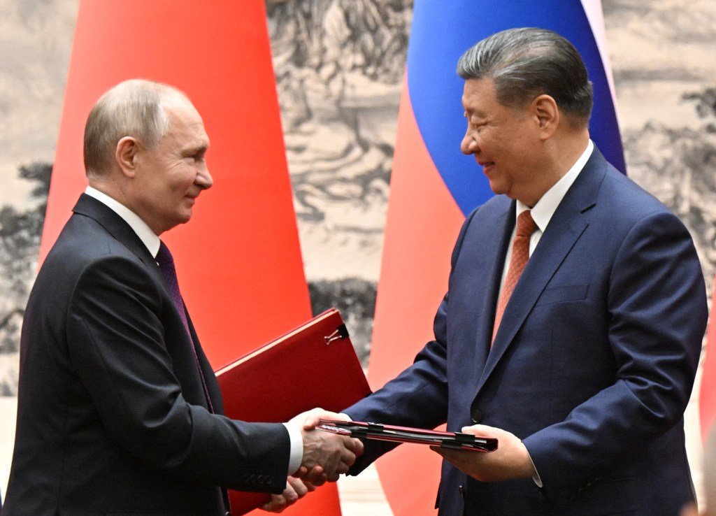 Nesta fotografia distribuída pela agência estatal russa Sputnik, o presidente da Rússia, Vladimir Putin, e o presidente da China, Xi Jinping, trocam documentos durante uma cerimônia de assinatura após suas conversações em Pequim, em 16 de maio de 2024.