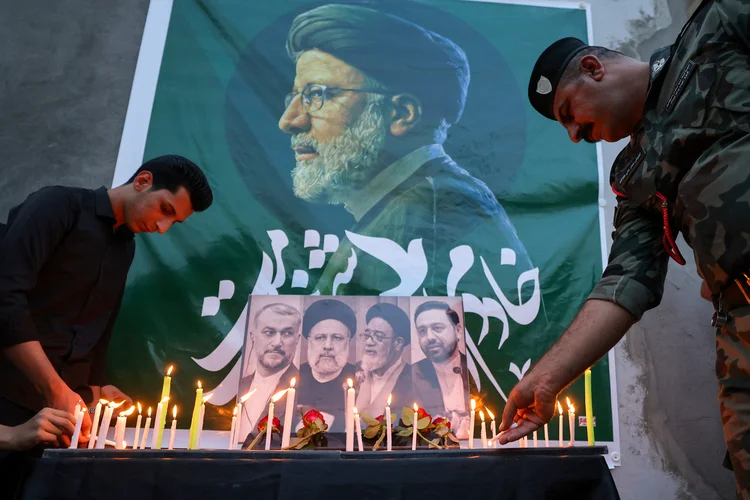 Iranianos colocam flores em homenagem ao presidente Ebrahim Raisi do lado de fora da embaixada do Irã em Bagdá (Ahmad Al-Rubaye/AFP)