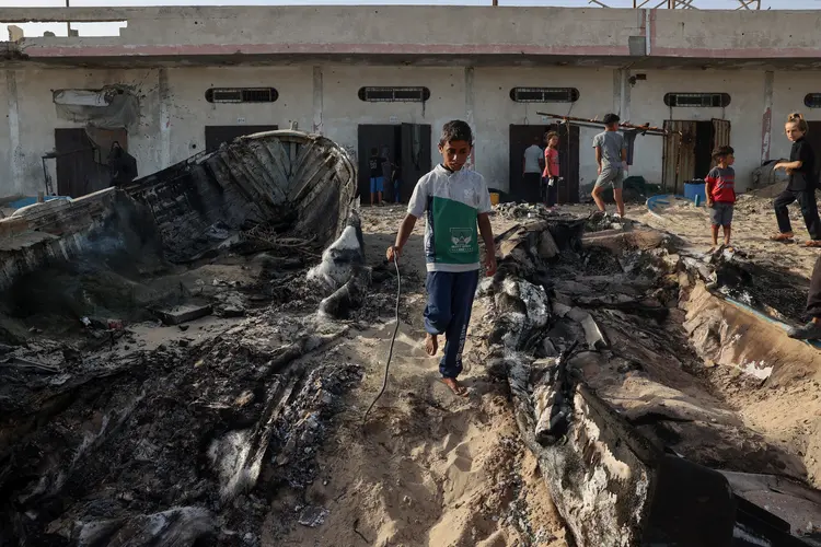 Garoto caminha em escombros após bombardeio israelense em Rafah (Photo by Eyad BABA / AFP)/AFP)