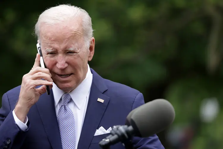 O presidente Joe Biden, ao telefone, durante evento na Casa Branca (Alex Wong/Getty Images)