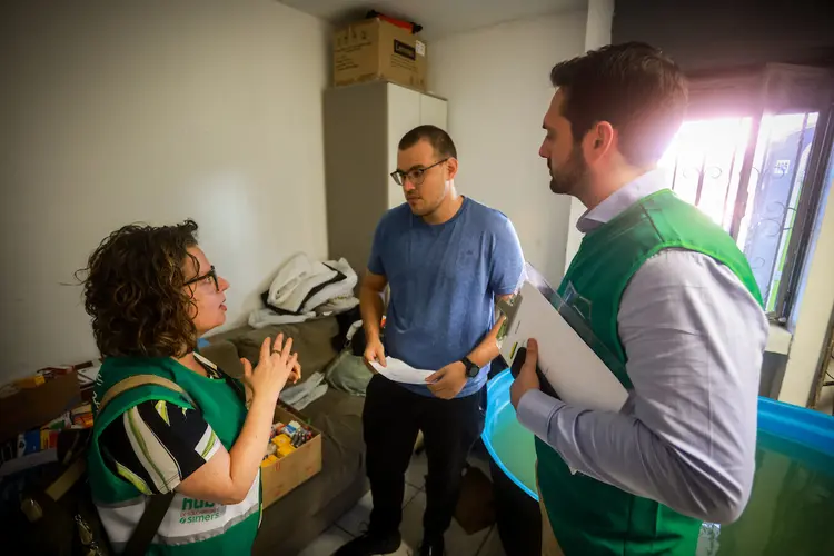 Fernando Uberti, vice-presidente do Sindicato Médico do Rio Grande do Sul, do lado direito, falando com profissionais que estão trabalhando em um dos abrigos de Porto Alegre (Sindicato Médico do Rio Grande do Sul/Divulgação)