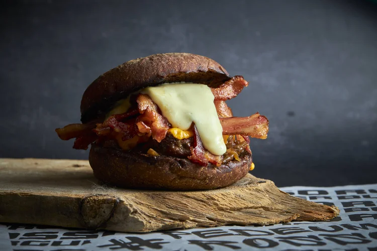 Rosso Burger: o sanduíche Il Rosso, que leva o nome da marca, é feito no pão preto, combinado com muito bacon, queijo cheddar, cebola caramelizada, maionese e um suculento burger. (Rodolfo Regini/Divulgação)