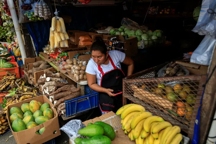 Uma mulher vende frutas e verduras em uma barraca de rua no setor La Chorrera, na Cidade do Panamá (AFP)