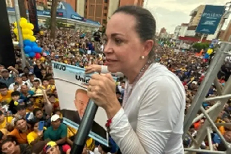 A liberal María Corina Machado segura um cartaz do candidato presidencial, Edmundo González, enquanto fala com seus partidários em Maracaibo, estado de Zulia, Venezuela, em 2 de maio de 2024

 (AFP/AFP)