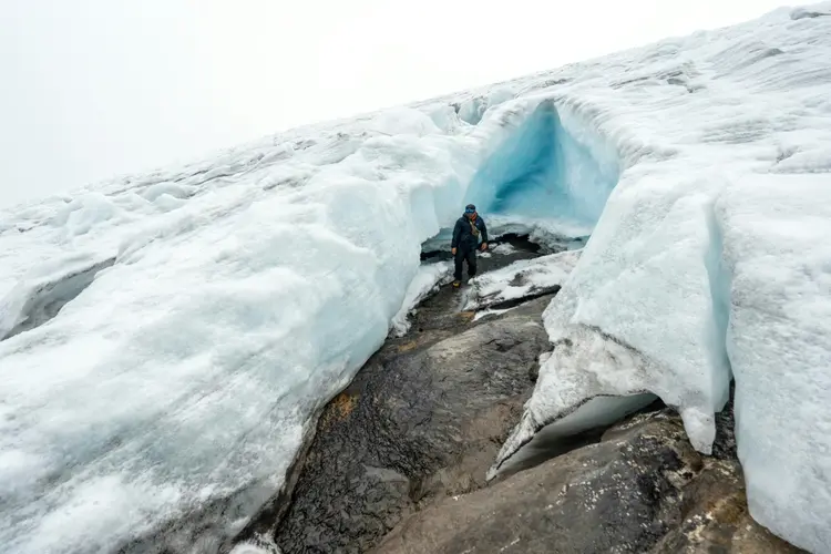 Desastre: guia caminha por uma fenda da geleira Ritacuba Blanco, na montanha nevada colombiana de El Cocuy, em abril de 2024 (AFP Photo)