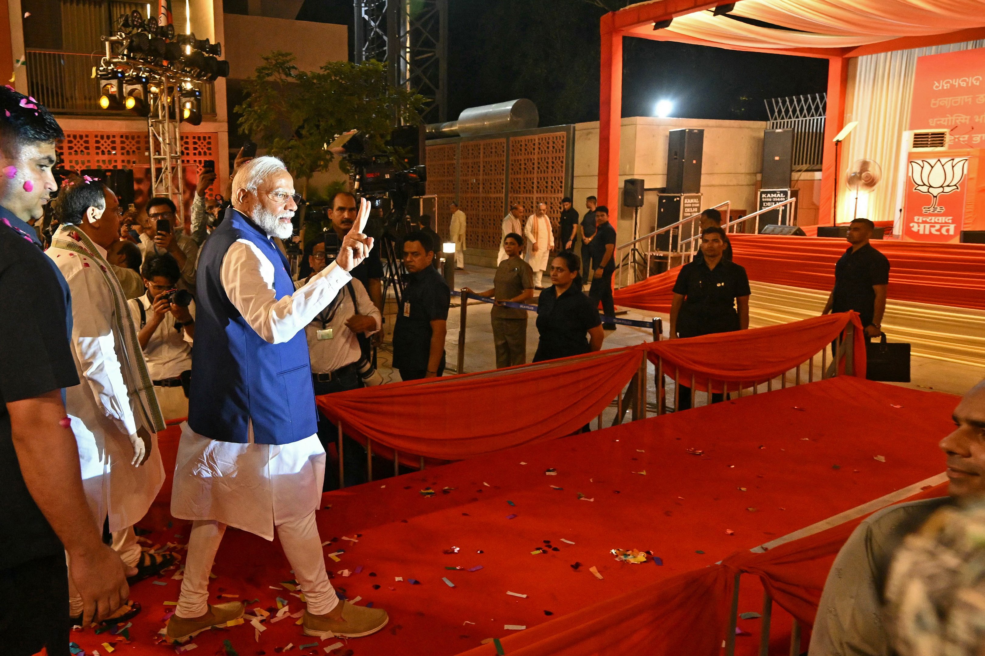 O Primeiro-Ministro da Índia, Narendra Modi (C), faz o sinal de vitória ao chegar na sede do Partido Bharatiya Janata (BJP) para comemorar a vitória do partido nas eleições gerais do país, em Nova Deli, em 4 de junho de 2024. Modi declarou a vitória eleitoral de seu partido e aliados no dia 4 de junho, mas a oposição afirmou que havia "punido" o partido governante, contrariando as previsões e reduzindo sua maioria parlamentar. (Foto por Money SHARMA / AFP)