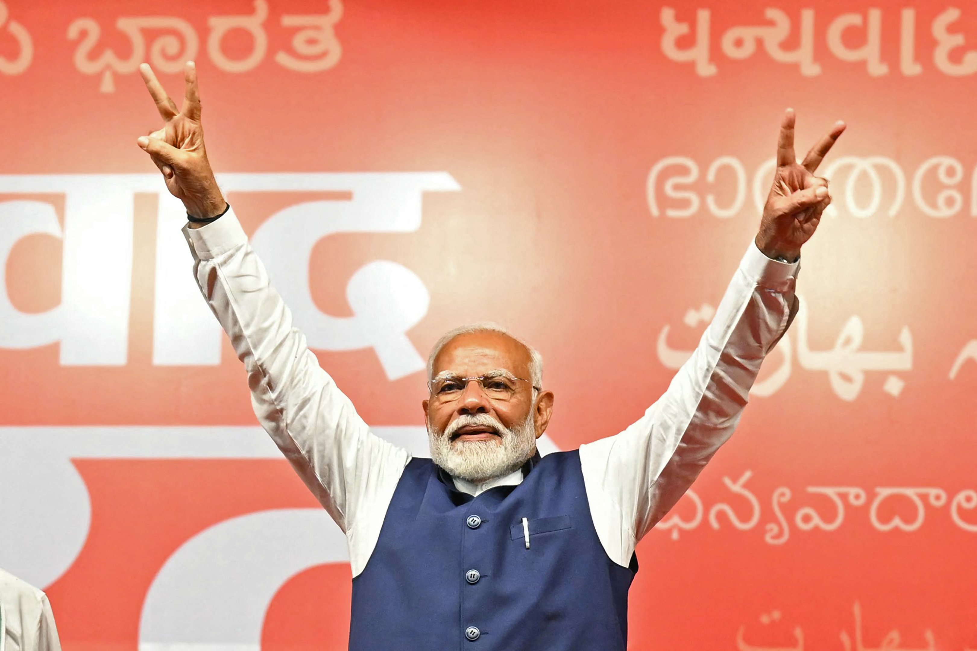 O Primeiro-Ministro da Índia, Narendra Modi, faz o sinal de vitória na sede do Partido Bharatiya Janata (BJP) para comemorar a vitória do partido nas eleições gerais do país, em Nova Deli, em 4 de junho de 2024. Modi declarou a vitória eleitoral de seu partido e aliados no dia 4 de junho, mas a oposição afirmou que havia "punido" o partido governante, contrariando as previsões e reduzindo sua maioria parlamentar. (Foto por Money SHARMA / AFP)