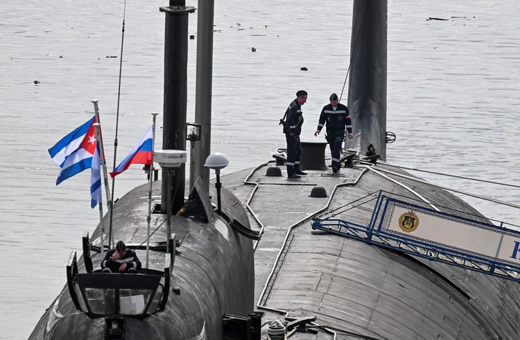 Fuzileiros navais russos caminham no topo do submarino nuclear russo Kazan, parte do destacamento naval russo em visita a Cuba, no porto de Havana em 14 de junho de 2024. A implantação incomum dos militares russos tão perto dos Estados Unidos — particularmente o poderoso submarino — ocorre em meio a grandes tensões sobre a guerra na Ucrânia, onde o governo apoiado pelo Ocidente está lutando contra uma invasão russa.