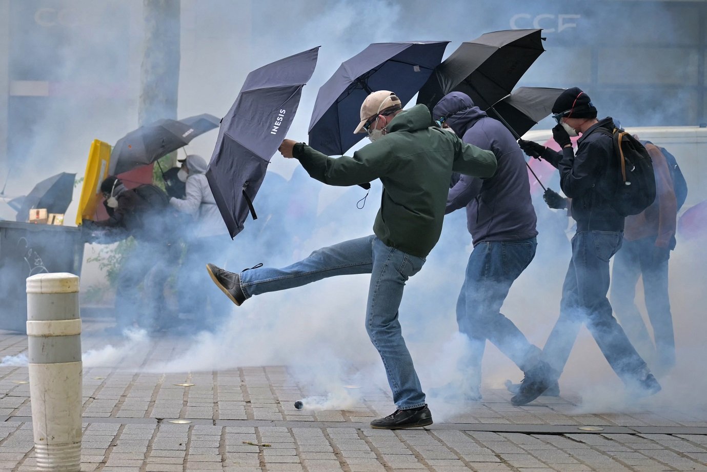 Demonstrators react as they are enveloped by teargas during an anti far-right rally after the French president called legislative elections following far-right parties' significant gains in European Parliament elections, in Rennes, western France on June 15, 2024. (Photo by LOU BENOIST / AFP)
