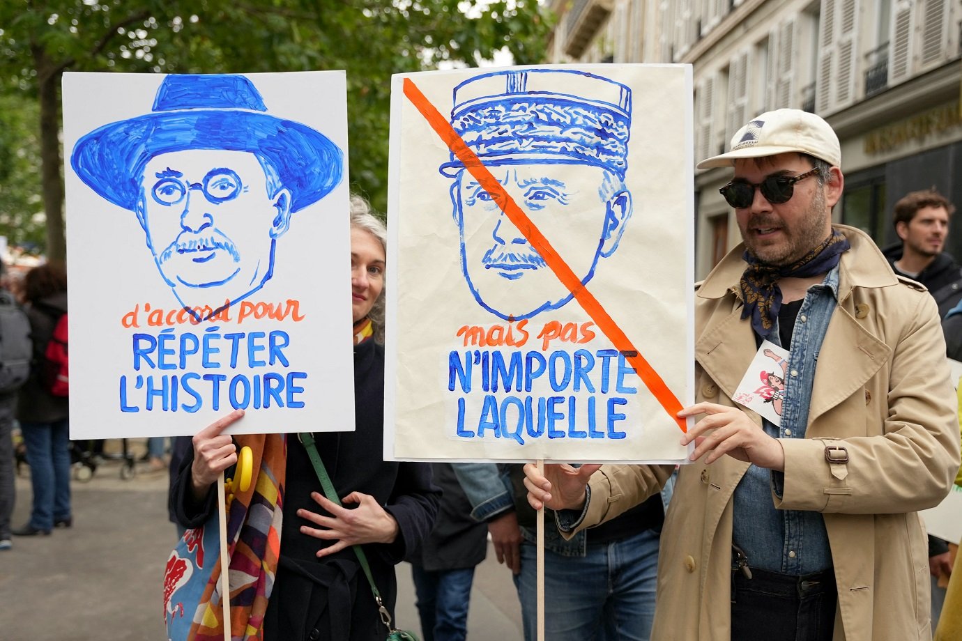 Demonstrators hold placards reading "Ok to repeat History" (L) and "But not any History" with illustration portraits representing French socialist politicain Leon Blum (L) and a crossed portrait of French head of the Vichy regime Marechal Petain during an anti far-right rally after French president called legislative elections following far-right parties' significant gains in European Parliament elections, in Paris on June 15, 2024. Less than a week after the earthquake of the dissolution, opponents of the far-right are called by trade unions, associations and the left-wing coalition of the "Nouveau Front Populaire" to take to the streets across France. (Photo by Zakaria ABDELKAFI / AFP)