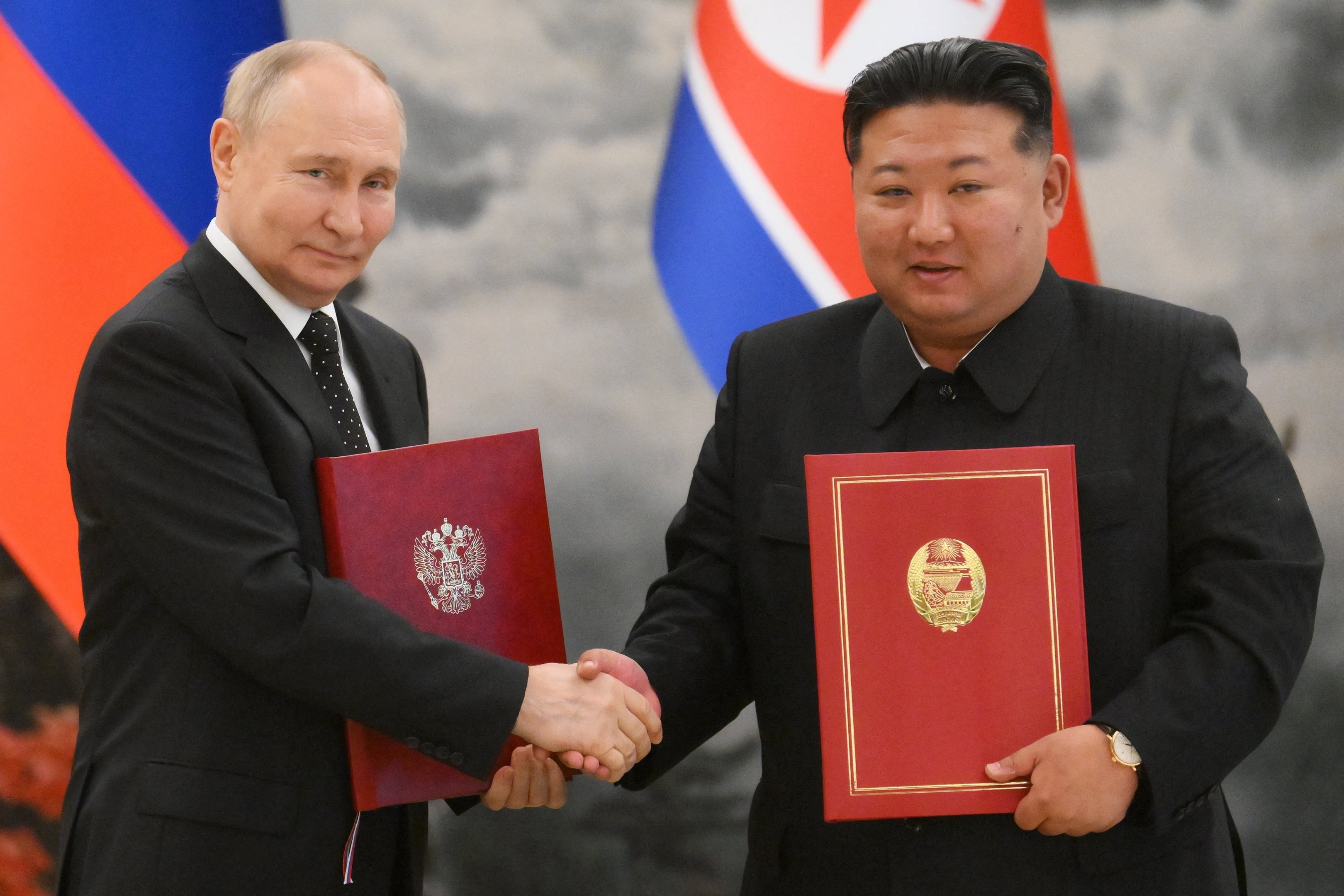 In this pool photograph distributed by the Russian state agency Sputnik, Russian President Vladimir Putin (L) shakes hands with North Korea's leader Kim Jong Un (R) after a signing ceremony following their bilateral talks at Kumsusan state residence in Pyongyang, on June 19, 2024.  (Photo by Kristina Kormilitsyna / POOL / AFP) / -- Editor's note : this image is distributed by the Russian state owned agency Sputnik -
