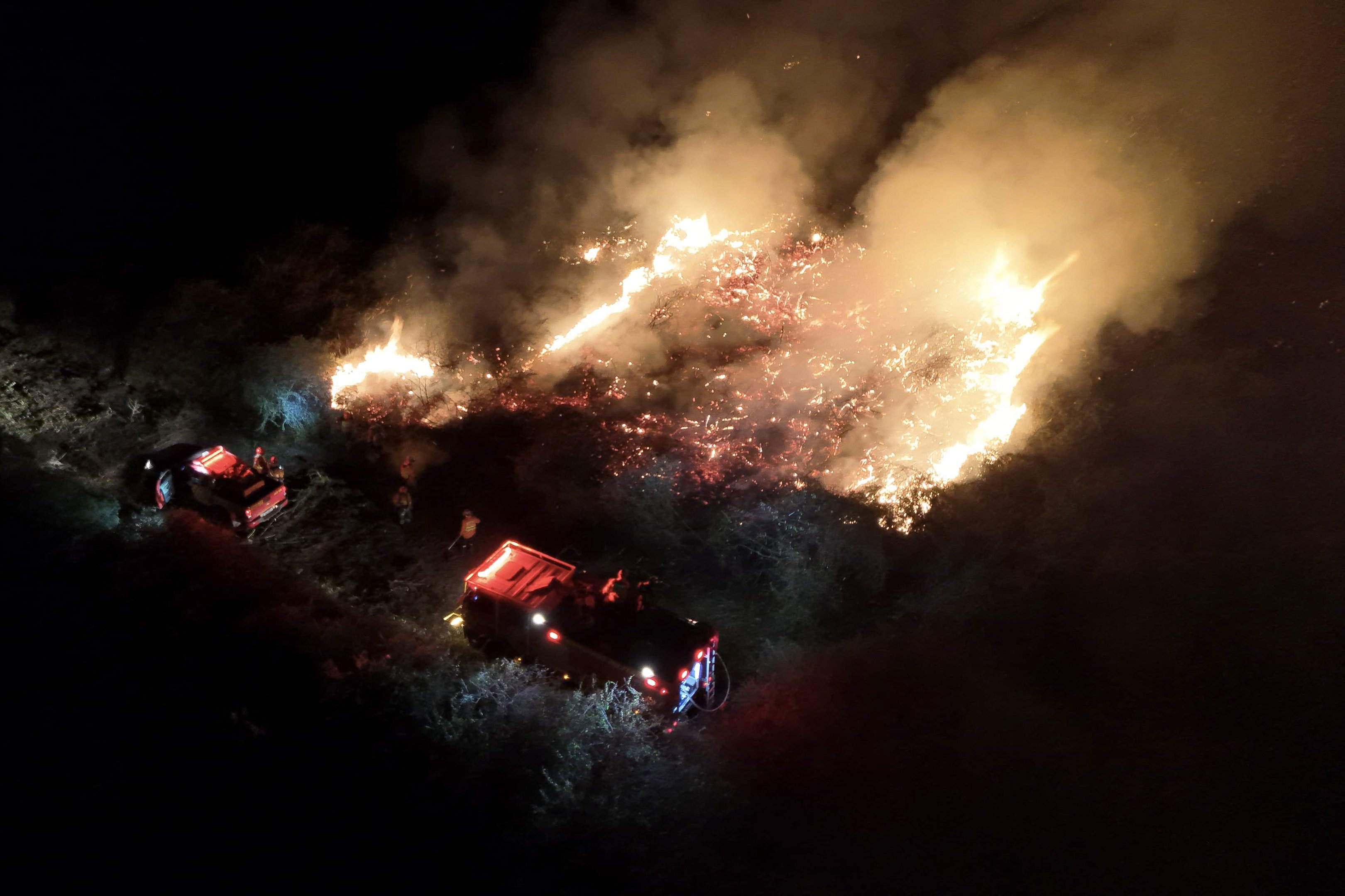 This handout photo released by the Mato Grosso do Sul Fire Department shows firefighters battling to control a wildfire at Pantanal Biome, Abobral Region, located in the city of Corumba, Mato Grosso do Sul State, Brazil, on June 21, 2024.  (Photo by Handout / MATO GROSSO FIREFIGHTERS DEPARTMENT / AFP) / RESTRICTED TO EDITORIAL USE - MANDATORY CREDIT 