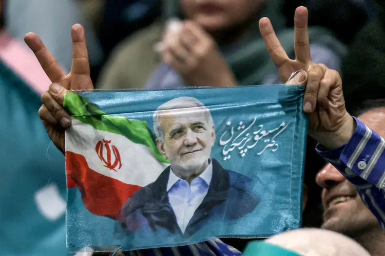Apoiador segura faixa de Pezeshkian, o único candidato reformista na eleição do Irã