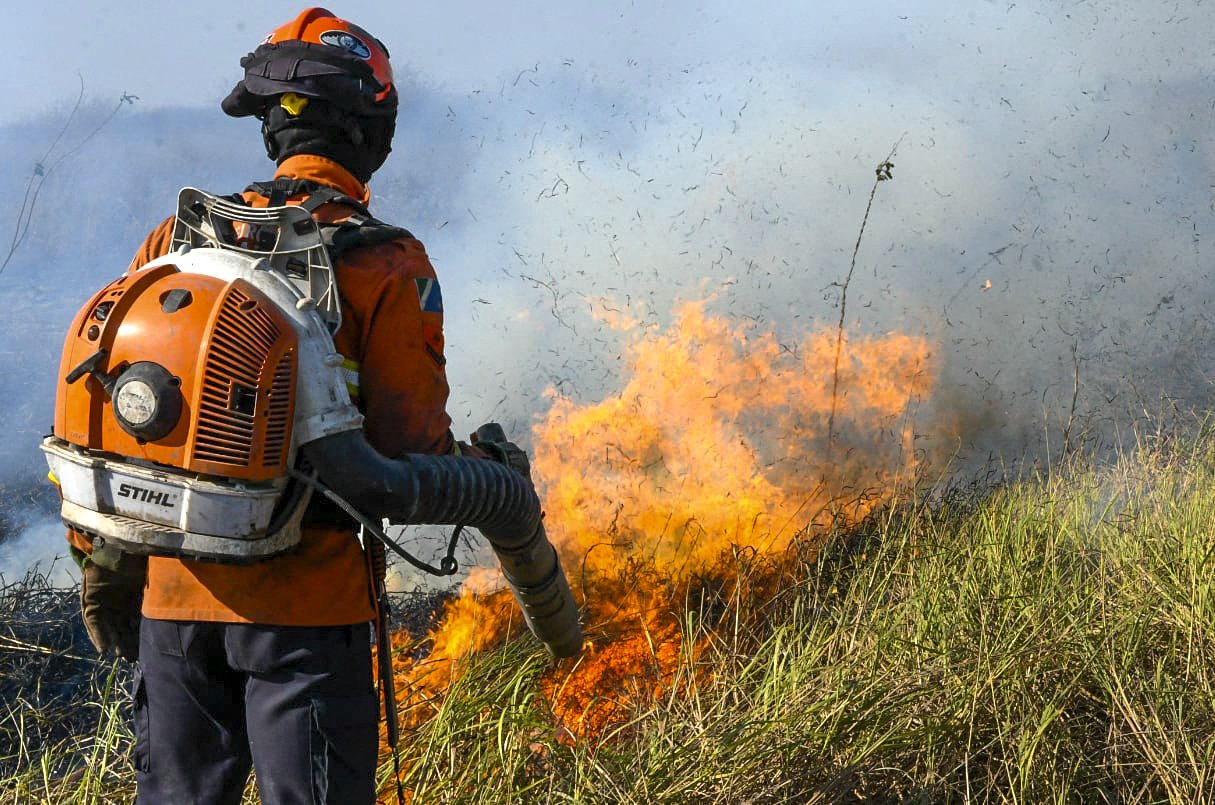This handout photo released by the Mato Grosso do Sul Government shows a firefighter battling to control a wildfire at Pantanal Biome, in the region of Corumba, Mato Grosso do Sul State, Brazil on June 23, 2024. (Photo by Handout / Mato Grosso do Sul State Government / AFP) / RESTRICTED TO EDITORIAL USE - MANDATORY CREDIT "AFP PHOTO /  Mato Grosso so Sul Government" - NO MARKETING NO ADVERTISING CAMPAIGNS - DISTRIBUTED AS A SERVICE TO CLIENTS