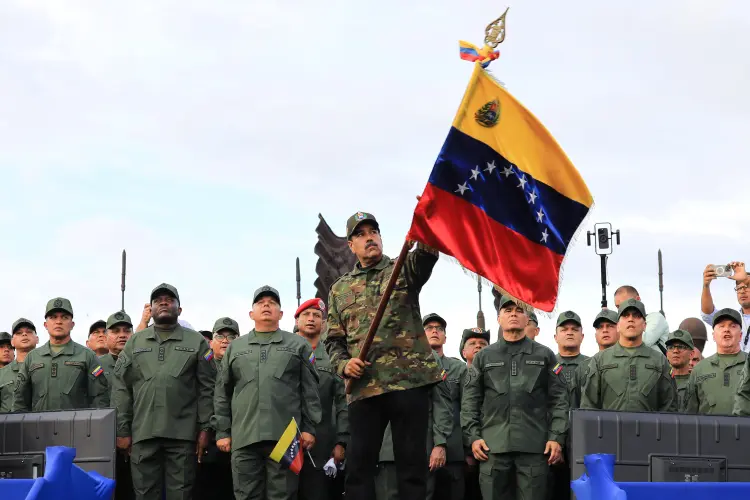 Nicolás Maduro com a bandeira da Venezuela durante parada militar em Carabobo
 (Presidência da Venezuela/AFP)