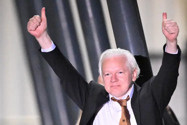 O fundador do WikiLeaks, Julian Assange, faz um sinal de positivo após chegar ao Aeroporto de Canberra em 26 de junho de 2024, após se declarar culpado em um tribunal dos EUA em Saipan de uma única acusação de conspiração para obter e disseminar informações de defesa nacional dos EUA. O fundador do WikiLeaks, Julian Assange, voltou para casa na Austrália para começar a vida como um homem livre em 26 de junho, após admitir que revelou segredos de defesa dos EUA em um acordo que abriu a porta para sua cela na prisão de Londres.  (William West/AFP)