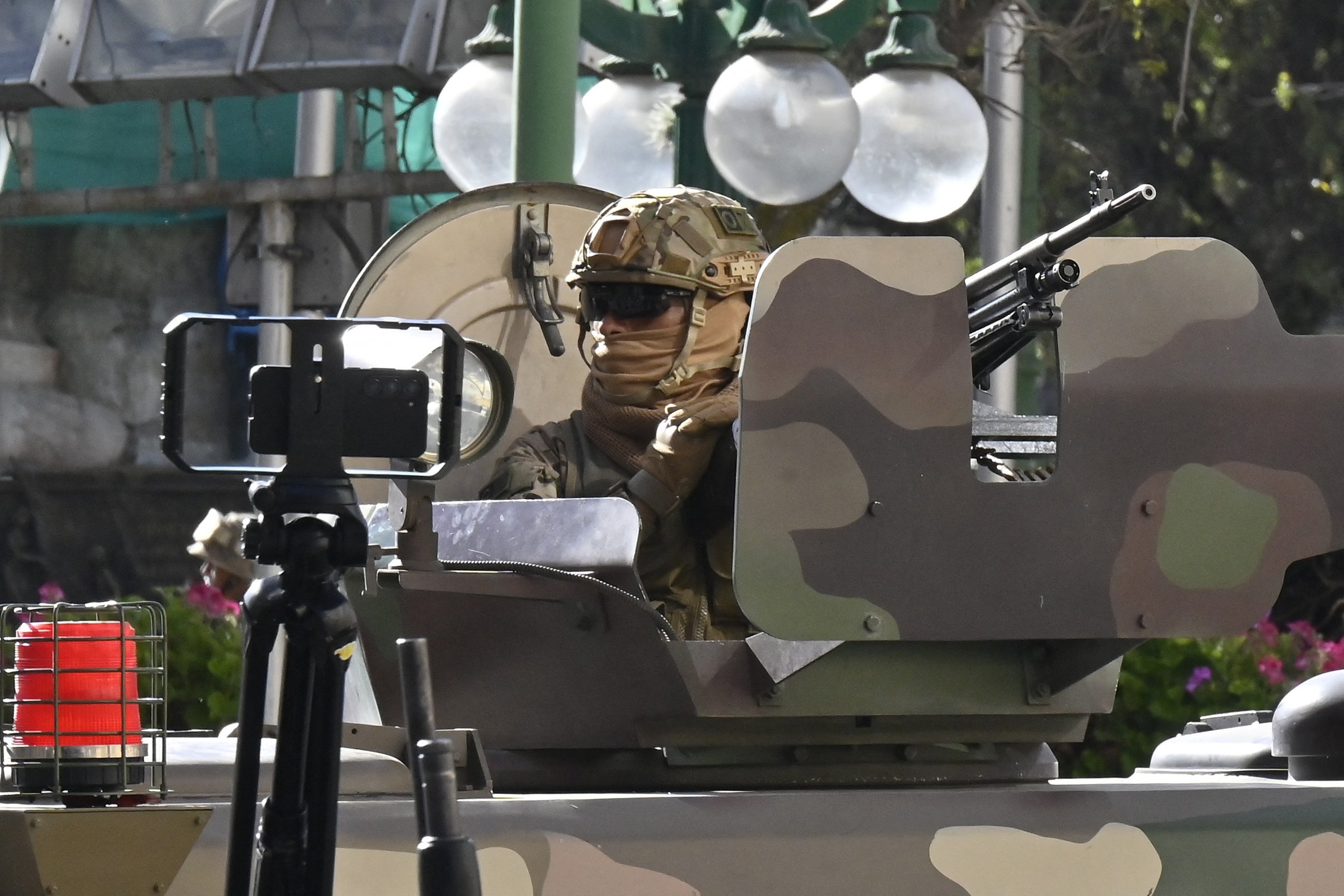 A soldier in an armored vehicle is deployed outside the Quemado Palace at the Plaza de Armas in La Paz on June 26, 2024. Bolivian President Luis Arce on Wednesday denounced the unauthorized gathering of soldiers and tanks outside government buildings in the capital La Paz, saying "democracy must be respected." "We denounce irregular mobilizations by some units of the Bolivian Army," Arce wrote on the X social network. Former president Evo Morales wrote on the same medium that "a coup d'état is brewing." (Photo by AIZAR RALDES / AFP)