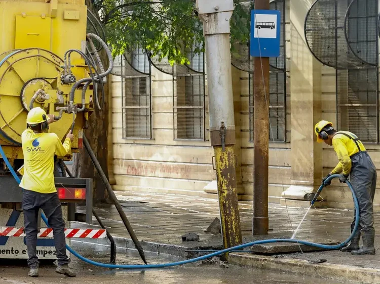 Funcionários fazem limpeza de rua após enchente que atingiu toda a cidade (Bruno Peres/Agência Brasil)