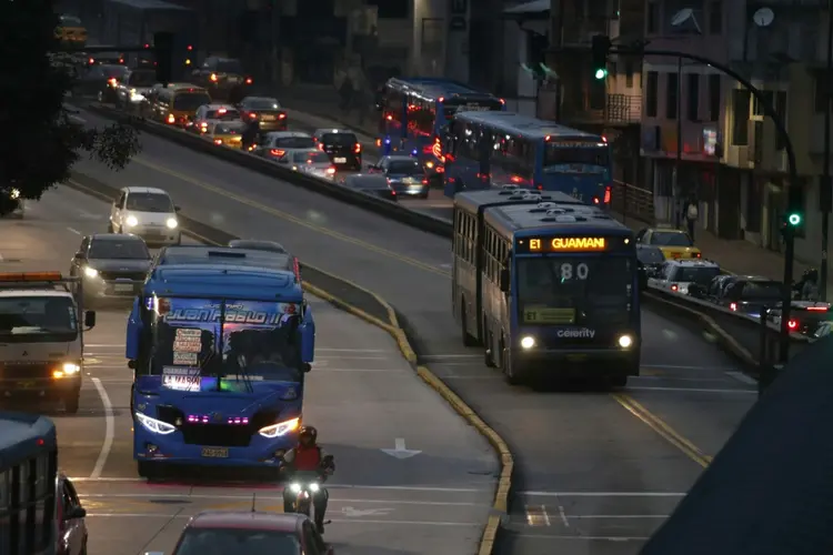 Dois ônibus circulam por uma via principal durante apagão em Quito, em 19 de junho de 2024 (AFP/AFP)