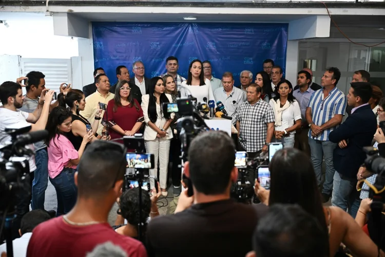 A líder da oposição venezuelana, María Corina Machado, fala ao lado do candidato presidencial da Plataforma de Unidade Democrática (PUD), Edmundo González Urrutia, durante entrevista coletiva em Caracas, em 17 de junho de 2024 (AFP)