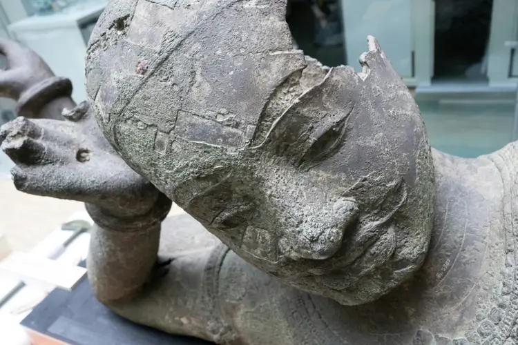 Uma grande estátua de bronze do século 11 do famoso Vishnu reclinado, recém-chegada do Camboja, é desembrulhada após sua chegada para ser restaurada no Centro de Pesquisa e Restauração de Museus da França (C2RMF) no museu do Louvre, em Paris, em 27 de maio de 2024 (AFP/AFP)