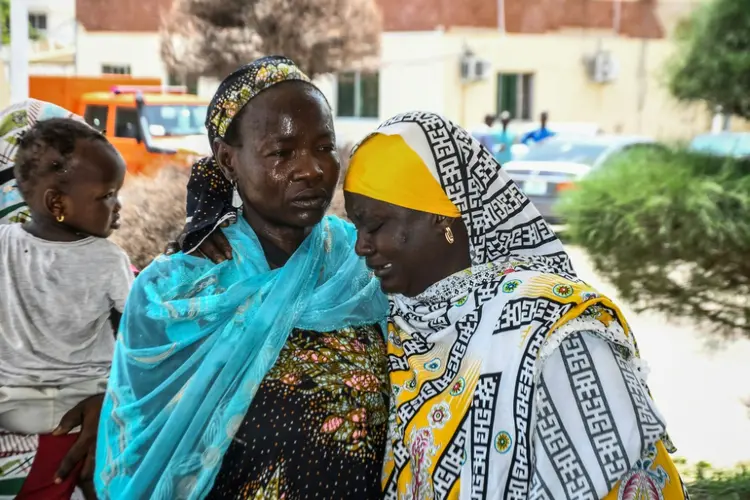 Familiares se confortam enquanto seus parentes são atendidos após uma série de ataques suicidas no nordeste da Nigéria (AFP/AFP)