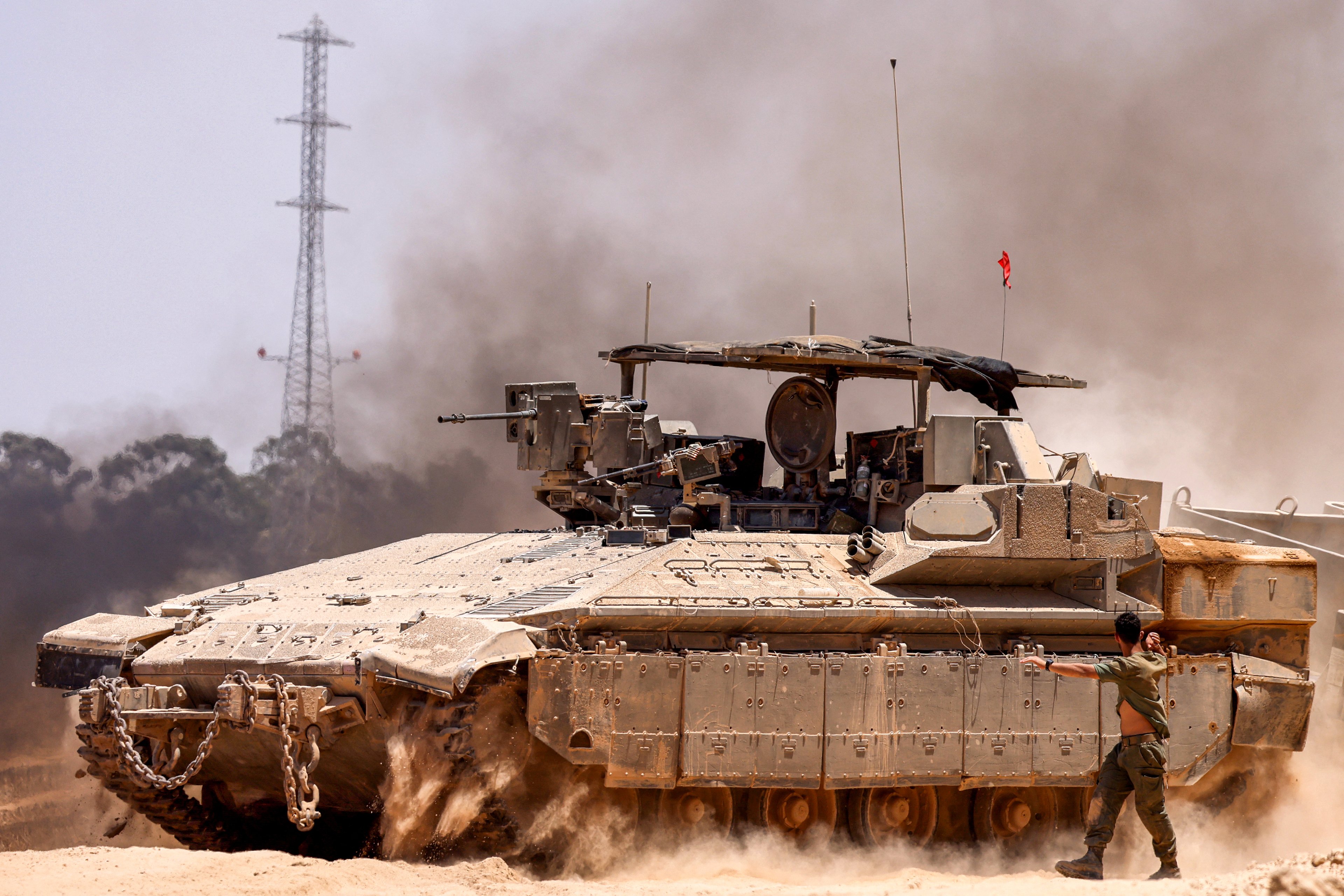 Um veículo blindado de transporte de pessoal (APC) do exército israelense se move para tomar posição em uma área próxima à fronteira com a Faixa de Gaza.