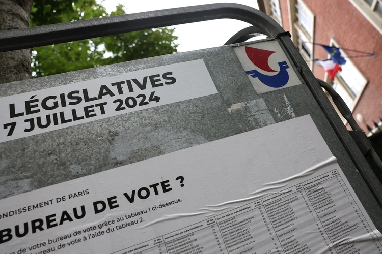 Uma placa indicando a localização dos centros de votação está do lado de fora de um centro de votação em Paris, em 3 de julho de 2024, antes do segundo turno das eleições legislativas da França, agendado para 7 de julho (Emmanuel Dunnand/AFP)