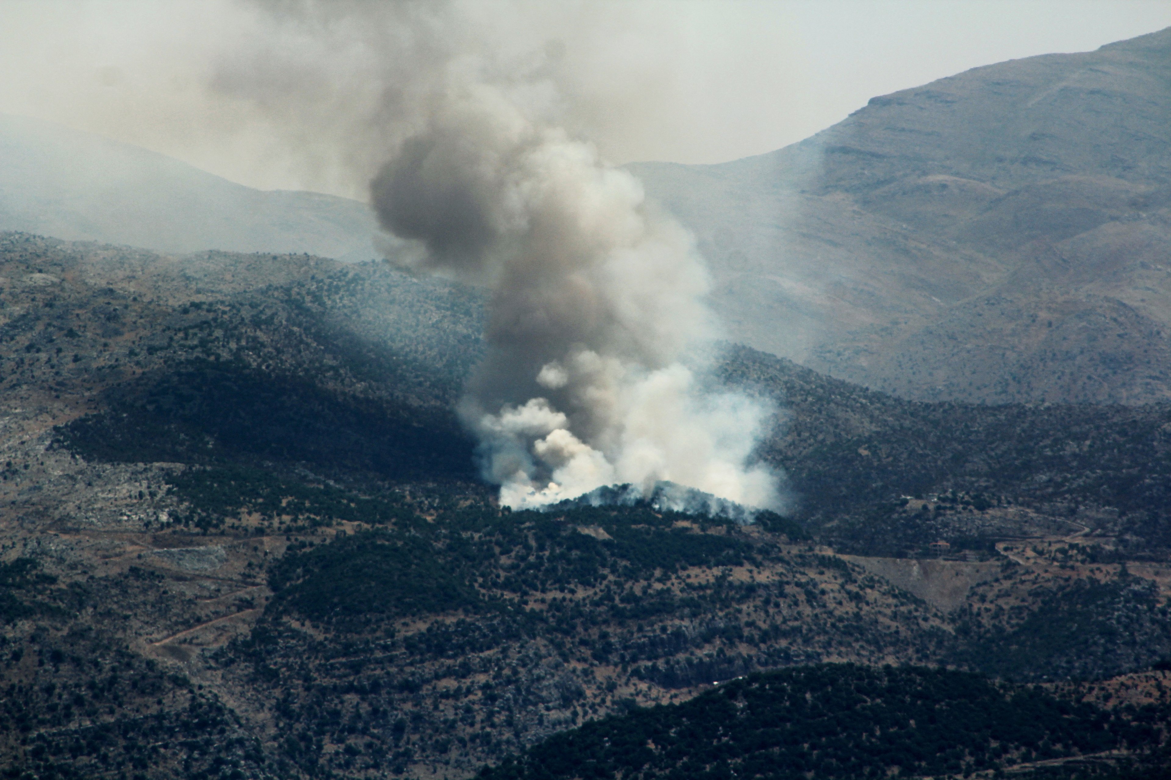 Fumaça sobe de incêndios florestais perto da vila de Shebaa, no sul do Líbano, próxima à fronteira norte de Israel, após a derrubada de um drone pelo exército israelense em 4 de julho de 2024, em meio aos confrontos transfronteiriços contínuos entre tropas israelenses e combatentes do Hezbollah. O Hezbollah do Líbano afirmou ter lançado mais de 200 foguetes e drones explosivos em 4 de julho em posições militares israelenses, enquanto as tensões aumentaram em meio à guerra de quase nove meses em Gaza. (Foto de RABIH DAHER / AFP)