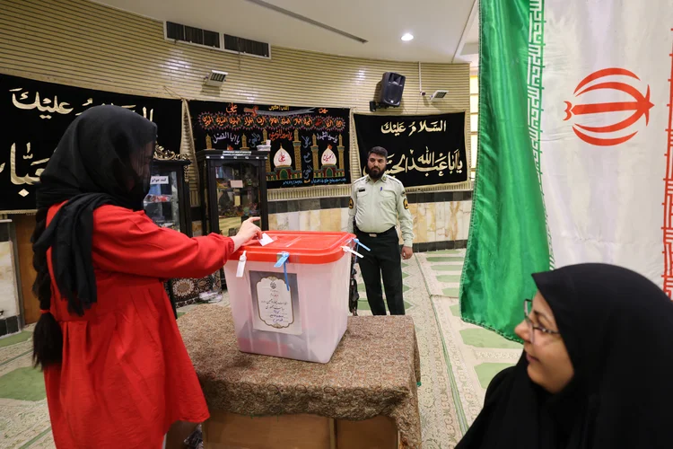 Mulher vota em seção eleitoral nesta sexta na capital Teerã ((Photo by ATTA KENARE / AFP))