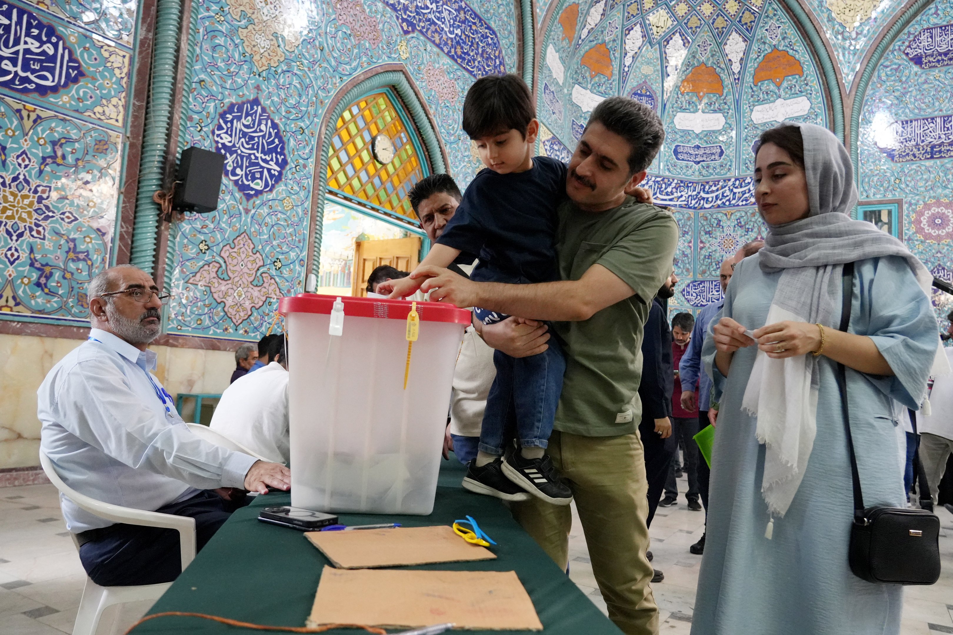 Um homem iraniano deposita seu voto com sua família presente em uma estação de votação em Teerã em 5 de julho de 2024. As urnas abriram em 5 de julho para a eleição presidencial de segundo turno do Irã, disse o ministério do interior, colocando o candidato reformista Masoud Pezeshkian contra o ultraconservador Saeed Jalili na corrida para suceder Ebrahim Raisi, que morreu em um acidente de helicóptero em maio.