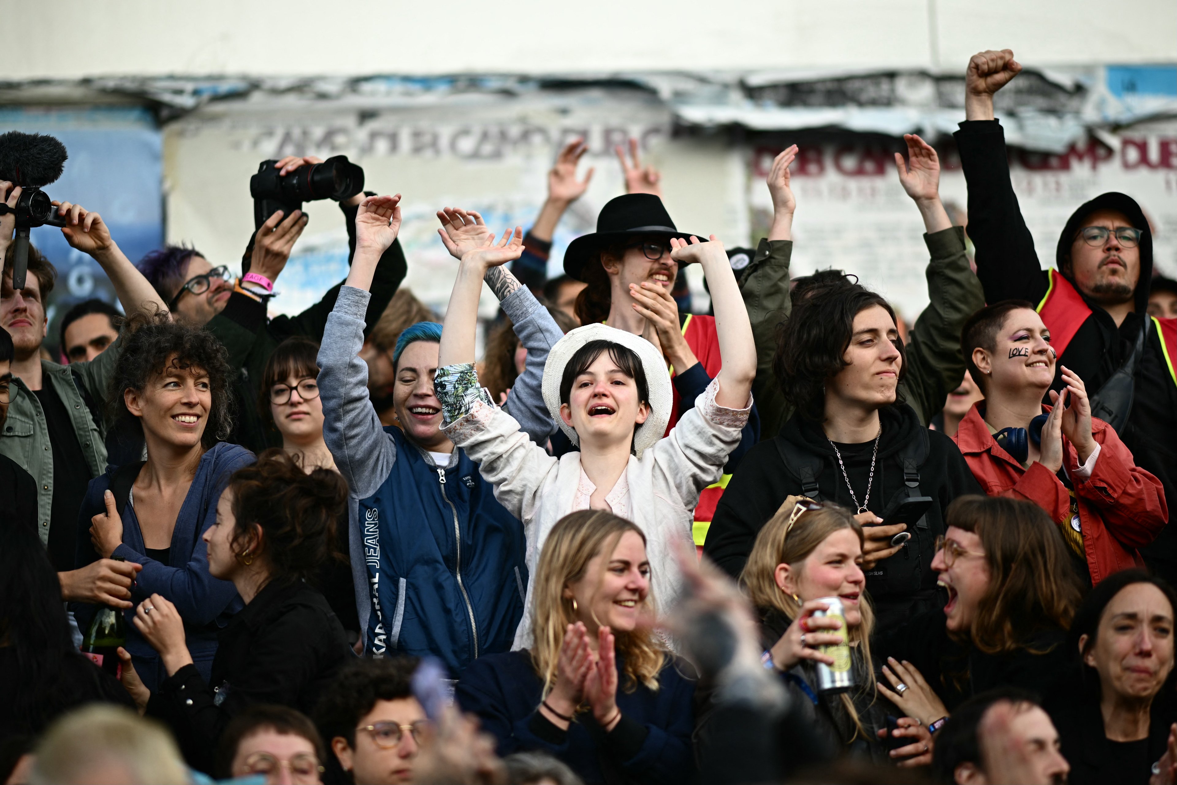 Participantes reagem enquanto ouvem o anúncio dos resultados projetados do segundo turno das decisivas eleições legislativas da França durante um comício em Nantes, oeste da França