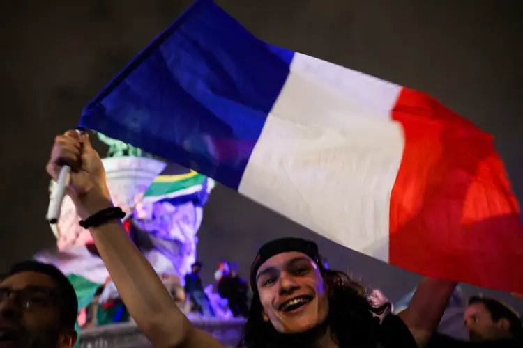 Ativista comemora resultado das eleições na França, em Paris (Emmanuel Dunand/AFP)