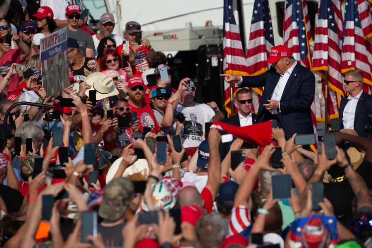 O ex-presidente dos EUA, Donald Trump, cumprimenta a multidão ao chegar a um evento de campanha na Butler Farm Show Inc. em Butler, Pensilvânia, em 13 de julho, antes de ser atacado (Rebecca Droke/AFP)