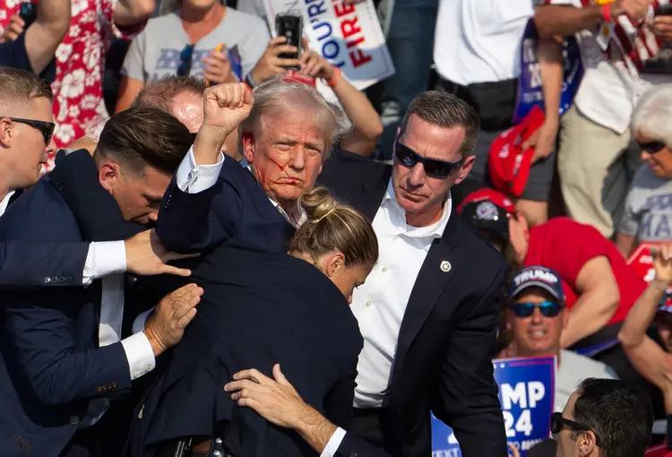 Republican candidate Donald Trump is seen with blood on his face surrounded by secret service agents as he is taken off the stage at a campaign event at Butler Farm Show Inc. in Butler, Pennsylvania, July 13, 2024. Donald Trump was hit in the ear in an apparent assassination attempt by a gunman at a campaign rally on Saturday, in a chaotic and shocking incident that will fuel fears of instability ahead of the 2024 US presidential election.
The 78-year-old former president was rushed off stage with blood smeared across his face after the shooting in Butler, Pennsylvania, while the gunman and a bystander were killed and two spectators critically injured. (Photo by Rebecca DROKE / AFP) ( Rebecca DROKE /AFP)