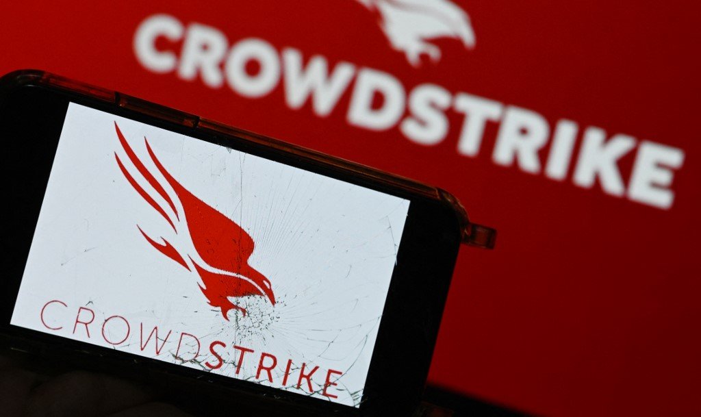 This photograph shows screens displaying the logo of "CrowdStrike" cybersecurity technology company in Paris on July 19, 2024, amid massive global IT outage. Airlines, banks, TV channels and other business across the globe were scrambling to deal with one of the biggest IT crashes in recent years on July 19, 2024, caused by an update to an antivirus program. Microsoft said in a technical update on its website that the problems began at 1900 GMT on July 18, affecting users of its Azure cloud platform running cybersecurity software CrowdStrike Falcon. (Photo by Stefano RELLANDINI / AFP)