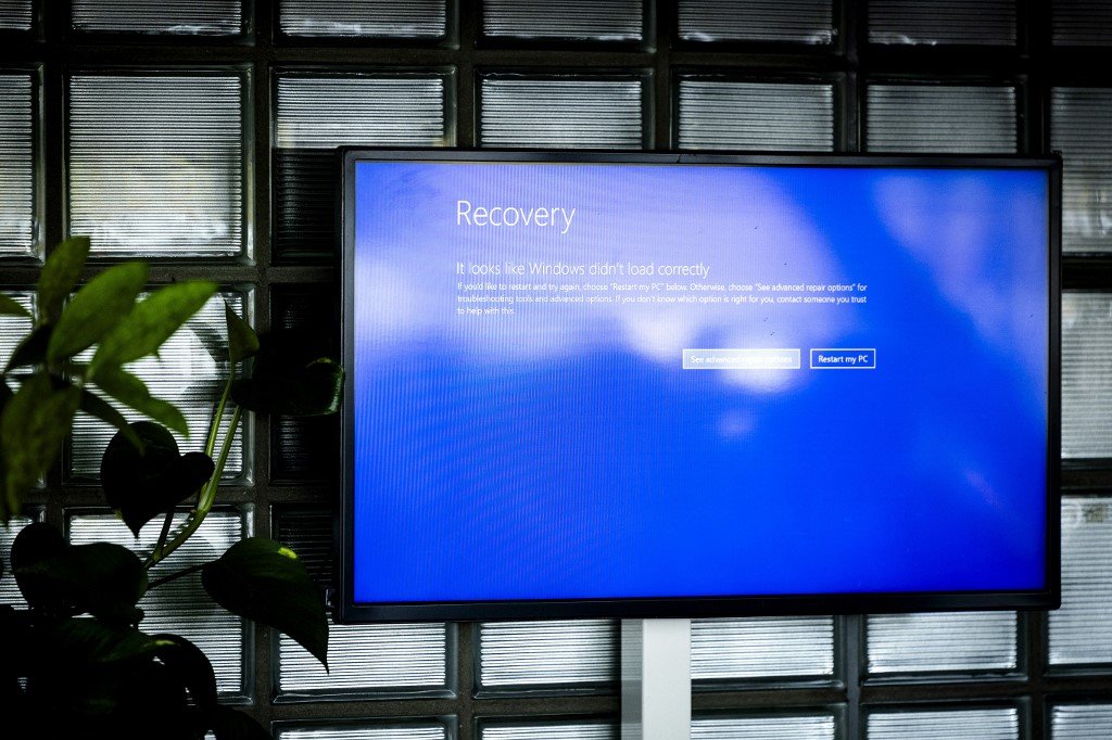 This photograph shows the Windows malfunction displayed on a screen at the TUI counter due a bug that caused a global IT outage affecting airports, it is currently not possible for most passengers to check in, at the Amsterdam-Schiphol airport, in Schiphol, on July 19, 2024. Amsterdam's Airport Schiphol, one of the busiest airports in Europe was affected by a global IT outage, which also affected Eindhoven airport, the Transavia airline and Dutch hospitals, on July 19, 2024. (Photo by Sem van der Wal / ANP / AFP) / Netherlands OUT