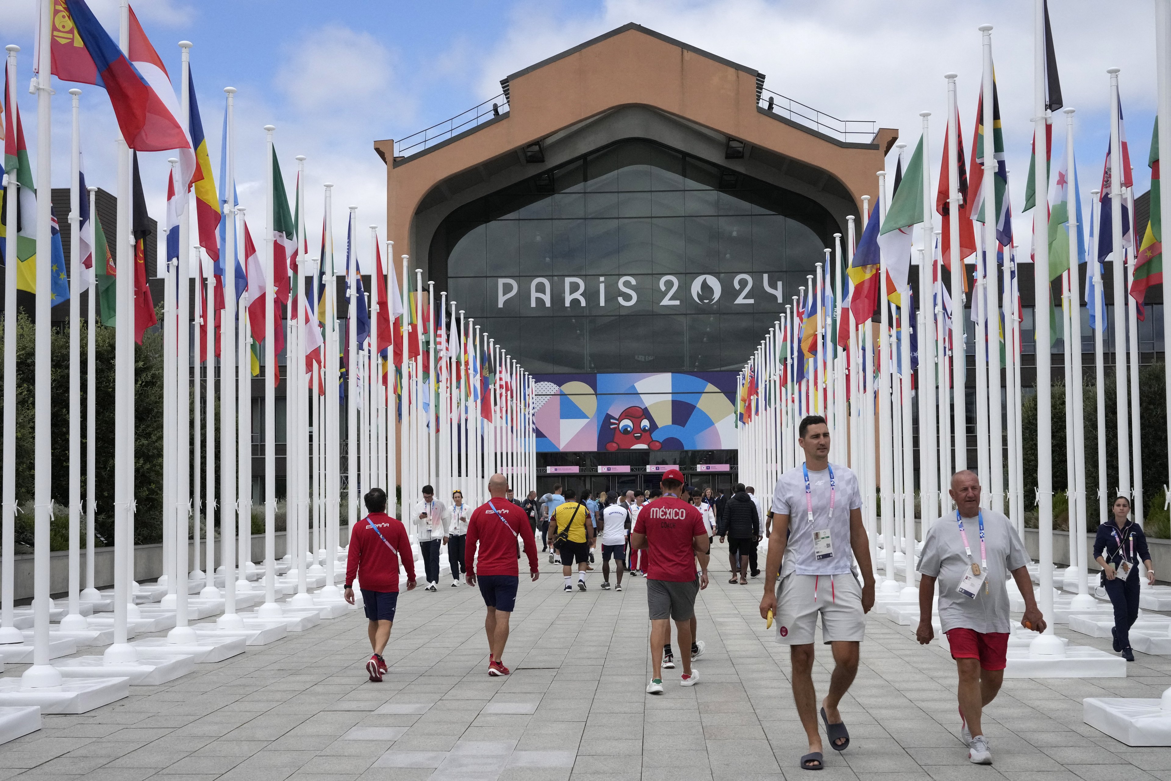Participantes caminham em direção ao refeitório da Vila Olímpica, em Saint-Denis