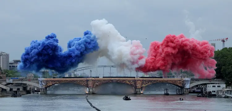 Nuvens de fumaça nas cores tricolores da bandeira da França são vistas na Pont d'Austerlitz durante a cerimônia de abertura. (AFP)